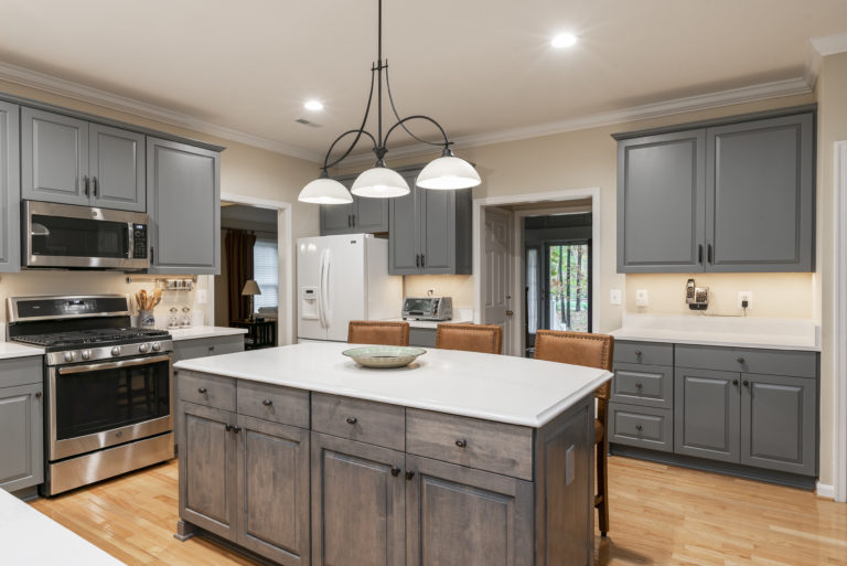 Beautiful pendent light centered above the contrasting driftwood stained island. 