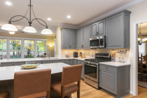 Tan island height stools give the gray kitchen a transitional flare.