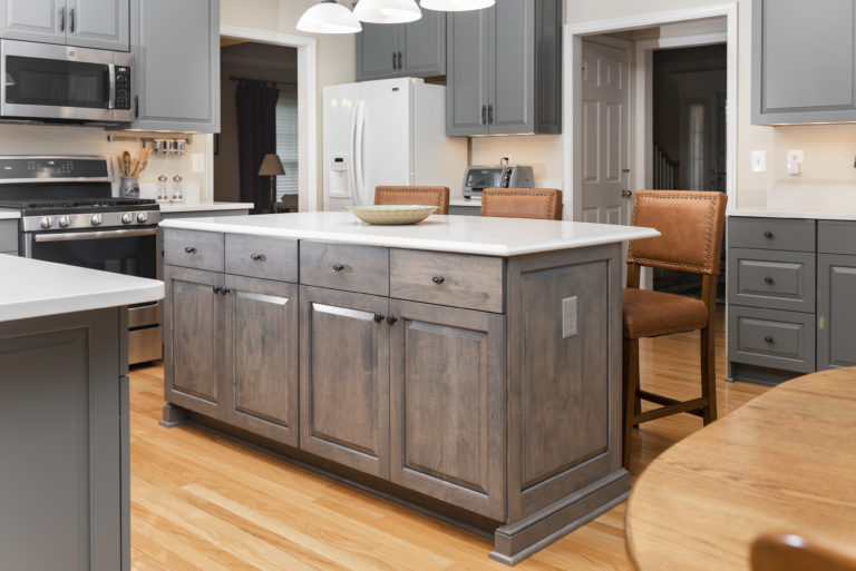 Contrasting island in a driftwood wiping stain and matching solid white quartz countertop. 
