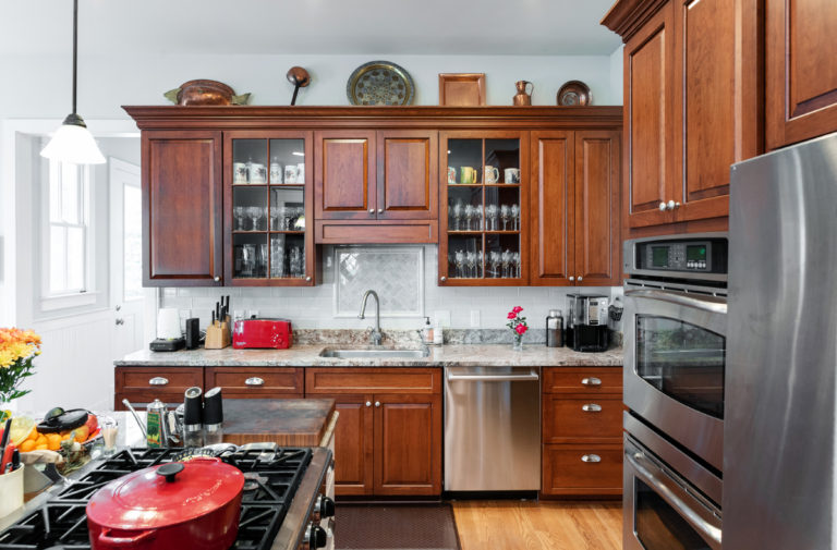 The gray tile backsplash enriches the granite countertops.   