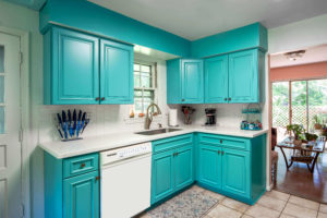 Blue-green cabinets contrasting nicely with solid white tile backsplash