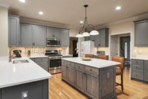 A newly renovated kitchen with gray maple cabinetry and glossy countertops
