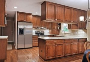 A kitchen full of brown hardwood cabinets complementing the glossy hardwood floor