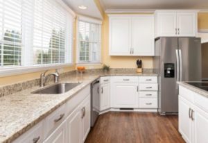 Newly remodeled kitchen with white cabinetry and updated countertops