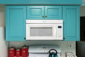 Custom, aqua-colored kitchen cabinets sitting above a microwave and stove