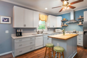 Kitchen with bluish grey cabinetry featuring a kitchen island