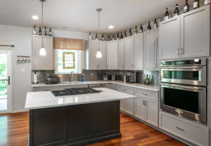 Modern kitchen island in a kitchen with grey white cabinets. 