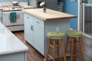 Light blue cabinets serving as the base of a countertop in the middle of the kitchen