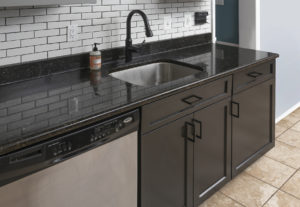 A kitchen with dark grey cabinet installed 
