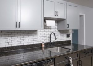 Light gray medium-density fiberboard cabinets complementing a dark-colored kitchen countertop