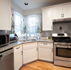 A double-corner window floods the narrow kitchen space with abundant natural light, illuminating every corner with a refreshing brightness.