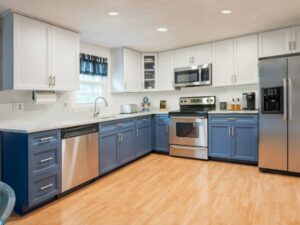 Light gray wall cabinets amd blue base cabinets with gray white granite countertop in Reisterstown, MD