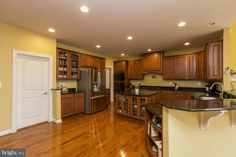 Kitchen with yellow walls light wood cabinets and light wood flooring