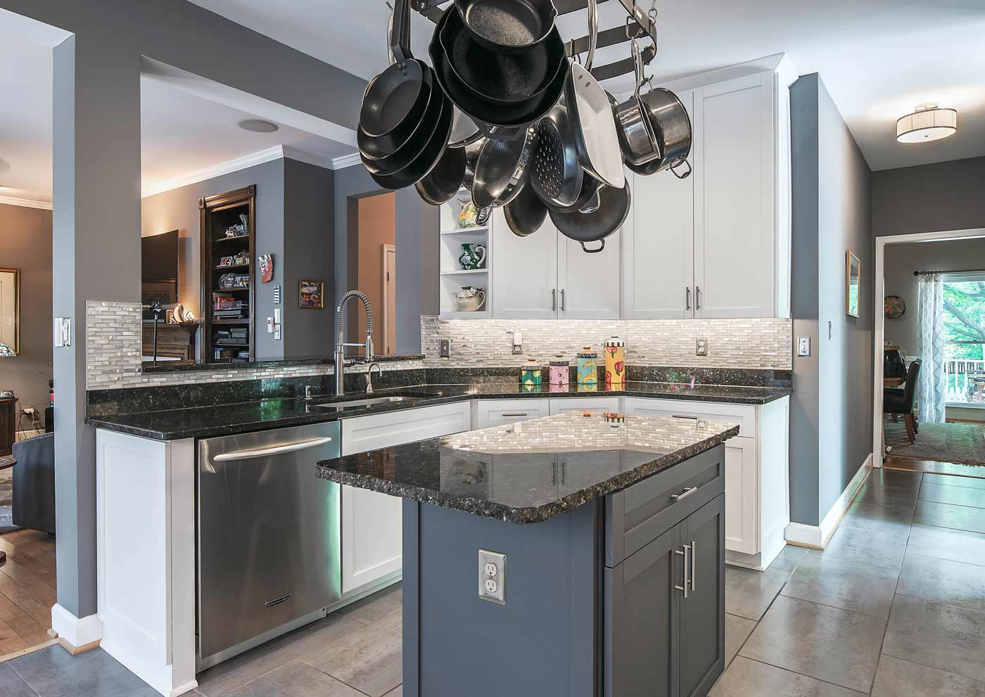White kitchen cabinets with a dark gray island and gray countertops