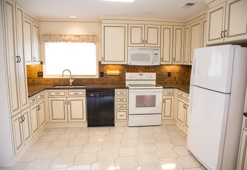 What a difference refacing can make! This kitchen was transformed with new countertops and new Parma doors. Helpful touches like trim, under-cabinet lighting, full extension drawers and a new cabinet add storage and usability.