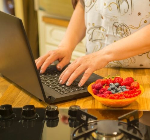 Typing on laptop in the kitchen. Dejan Cavic