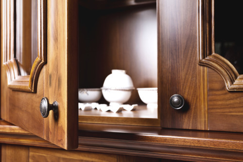 cabinet doors opening to show cups on a shelf.