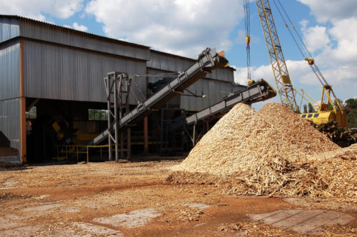  wood chips going down a metal chute into a MDF producing facility
